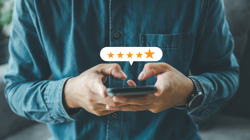 Close,Up,Man,Hand,Using,Smartphone,With,Popup,Five,Star
